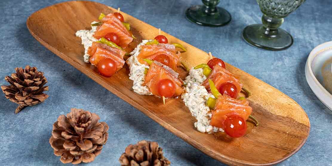 Brochetas de salmón ahumado noruego con piparras, cherrys y salsa tártara